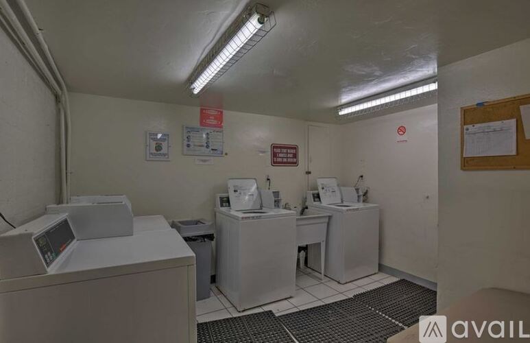 A clean, white medical room with a monitor and sink.
