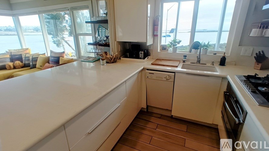 A kitchen with white appliances and wooden floors.