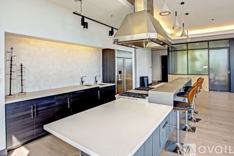 A modern kitchen with a large island and stainless steel appliances.