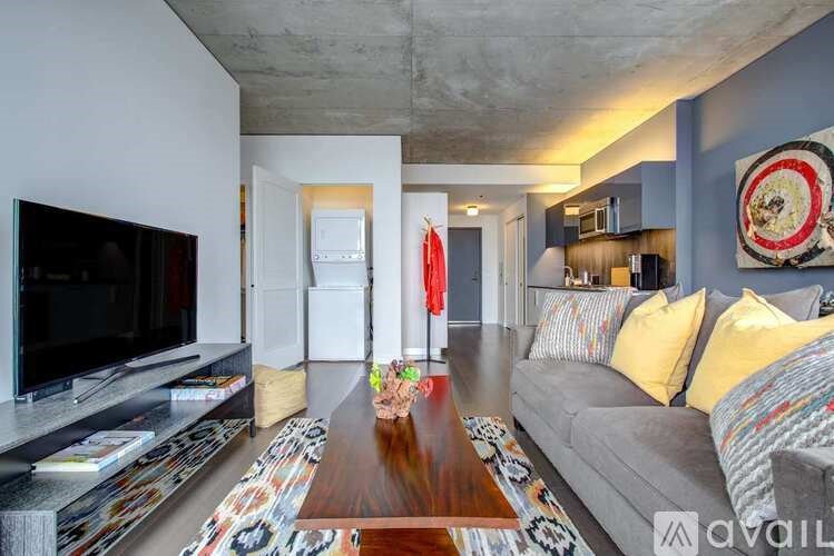 A living room with a grey couch and a wooden coffee table.