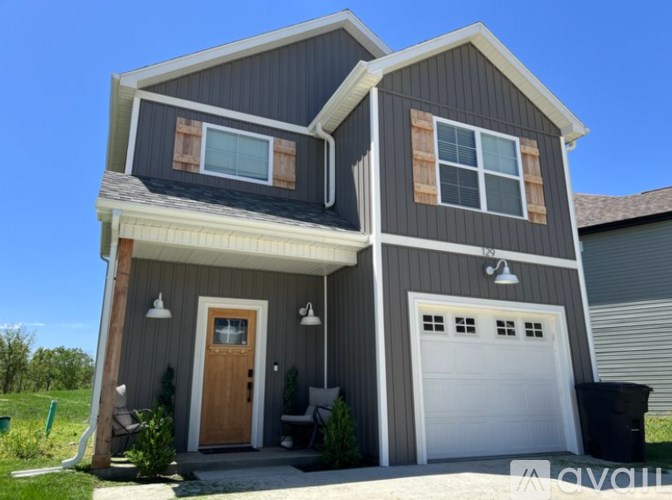A two-story house with a garage and a brown door.