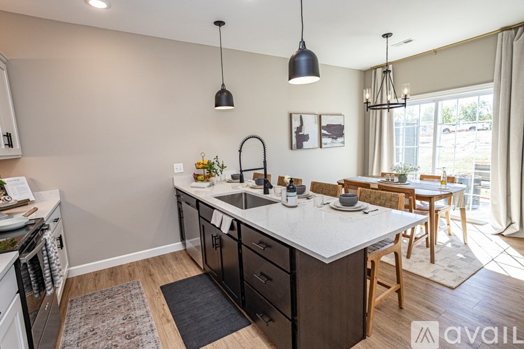 A kitchen with a large island and pendant lights.