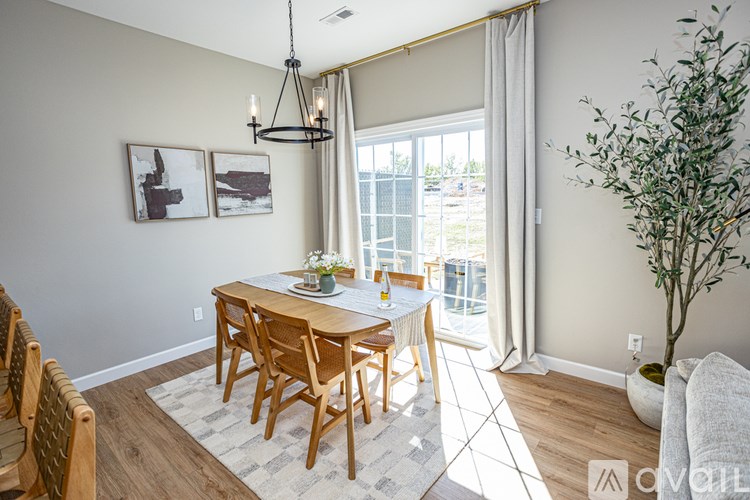 A dining room with a wooden table and chairs.