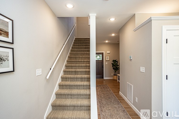 A hallway with a staircase and a door.