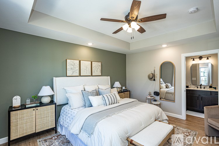 A bedroom with a bed, nightstands, and a ceiling fan.