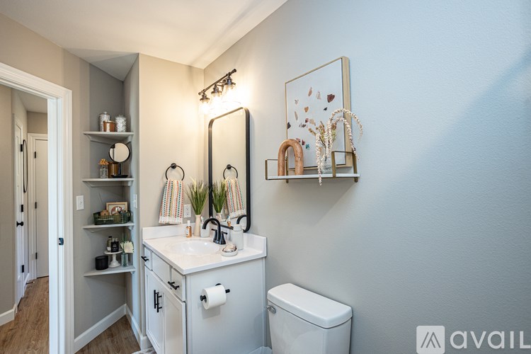 A bathroom with a white toilet and a white sink with a mirror above it.