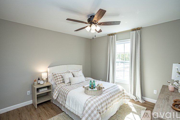 A bedroom with a bed, nightstand, and window.