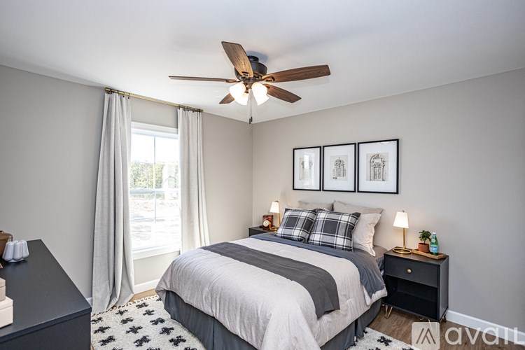 A bedroom with a bed, nightstands, and a ceiling fan.