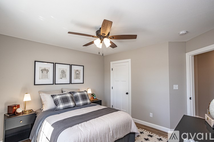 A bedroom with a bed, nightstand, and a ceiling fan.