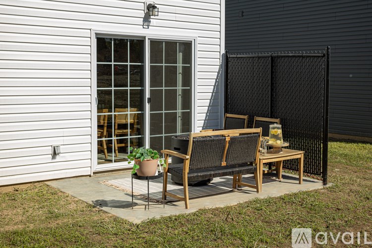 A patio with a chair and table outside a house.