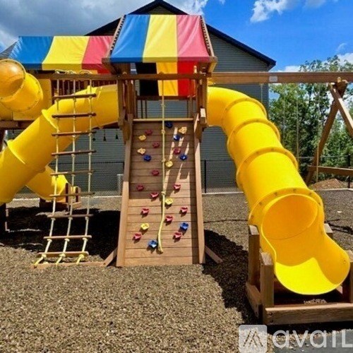 A yellow slide with a red, white and blue striped roof.