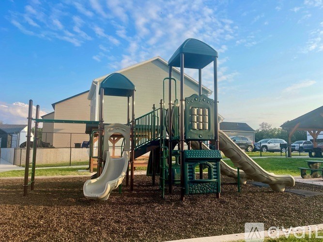 A playground with a green slide and a white slide.