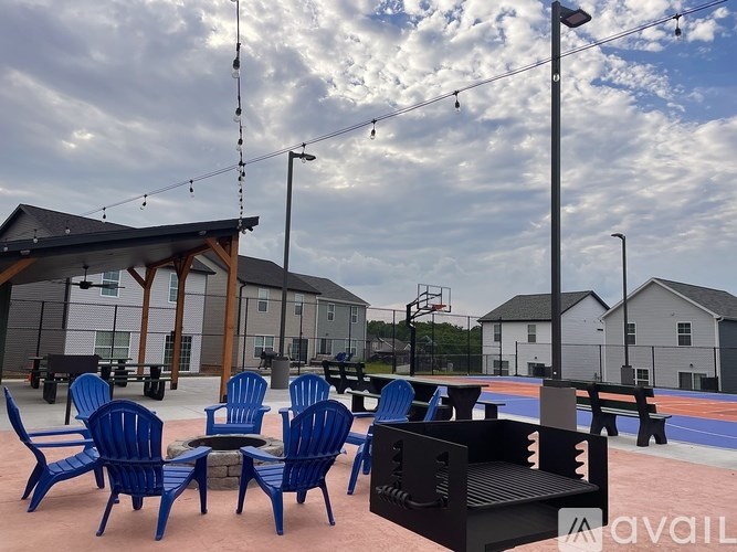 A park with blue chairs and a black speaker.