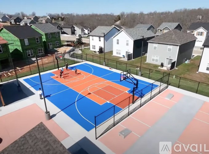 A basketball court is surrounded by houses.