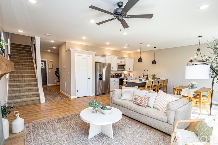 A living room with a couch, coffee table, and a ceiling fan.