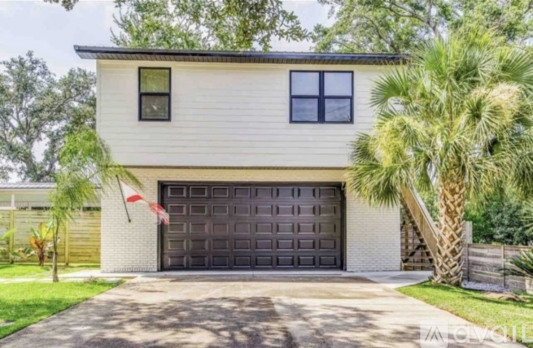 A two-story house with a garage door and a flag on the left side.