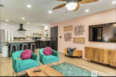 A living room with two green chairs and a wooden coffee table.
