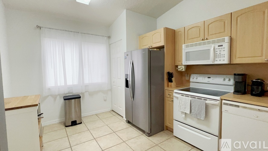 A kitchen with a refrigerator, oven, and microwave.