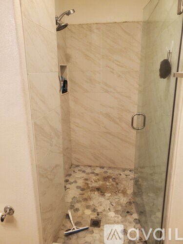 A bathroom with a shower and a tiled floor.