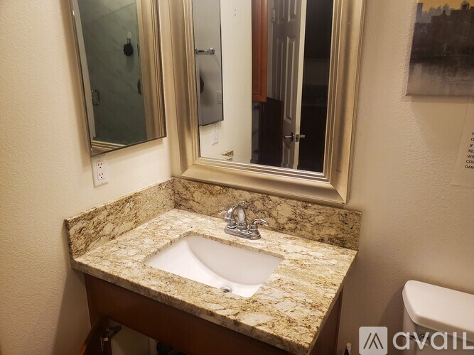 A bathroom with a marble countertop and a double sink.