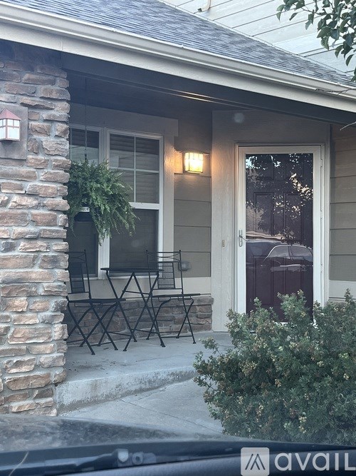 A house with a stone pillar and a patio table.