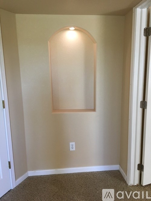 A room with a white door and a light switch on the wall.