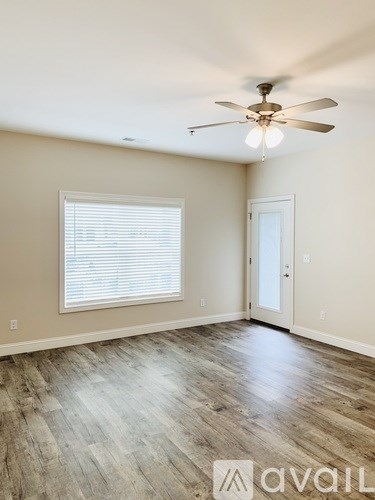 A room with a ceiling fan and a window with blinds.