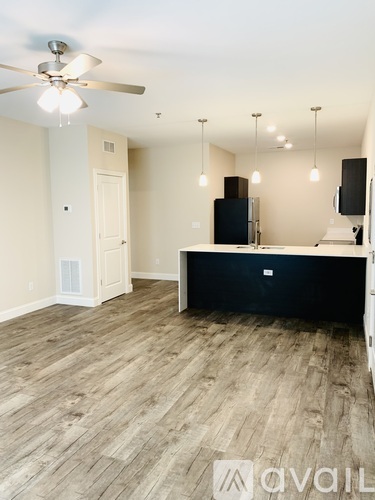 A room with a ceiling fan and a black cabinet.