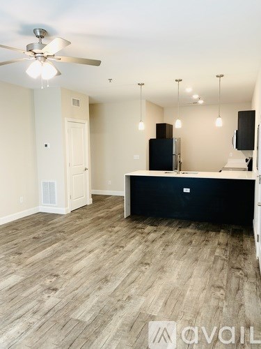 A room with a ceiling fan and a black cabinet.