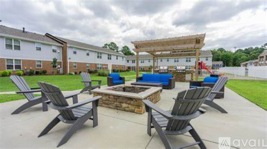 A patio with a fire pit and chairs.