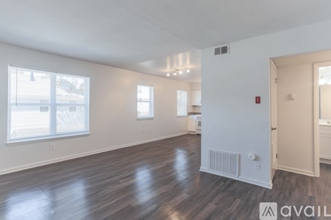 A spacious room with wooden floors and white walls.