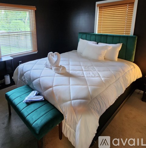 A white bed with a green headboard and a white pillow.