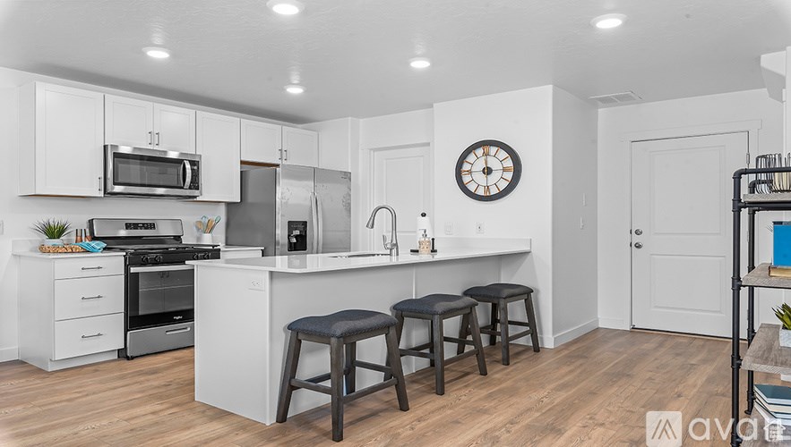 A kitchen with white cabinets and a clock on the wall.