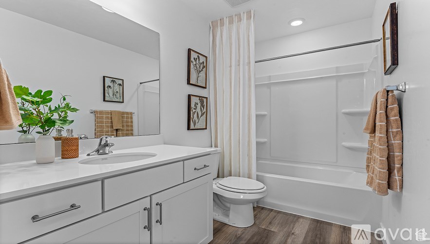 A white bathroom with a toilet, sink, and bathtub.