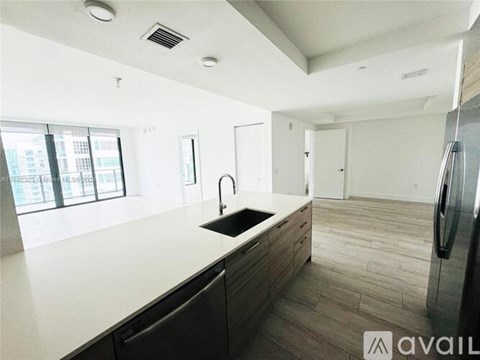 A modern kitchen with a sink and refrigerator.