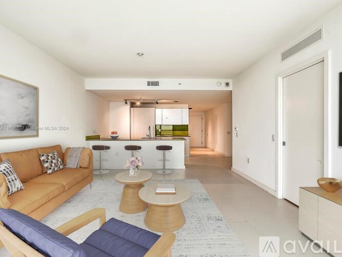 A living room with a sofa, a coffee table, and a television.