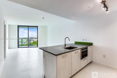A kitchen with a sink and a window overlooking a cityscape.