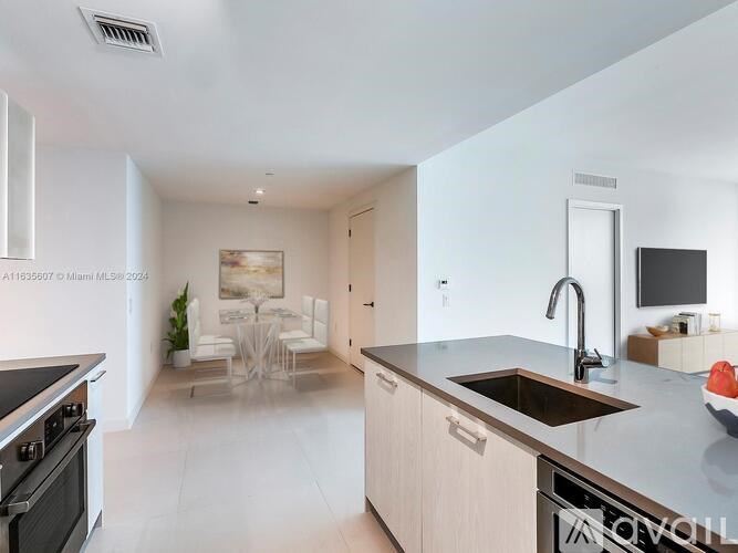 A modern kitchen with a stove top oven and a sink.