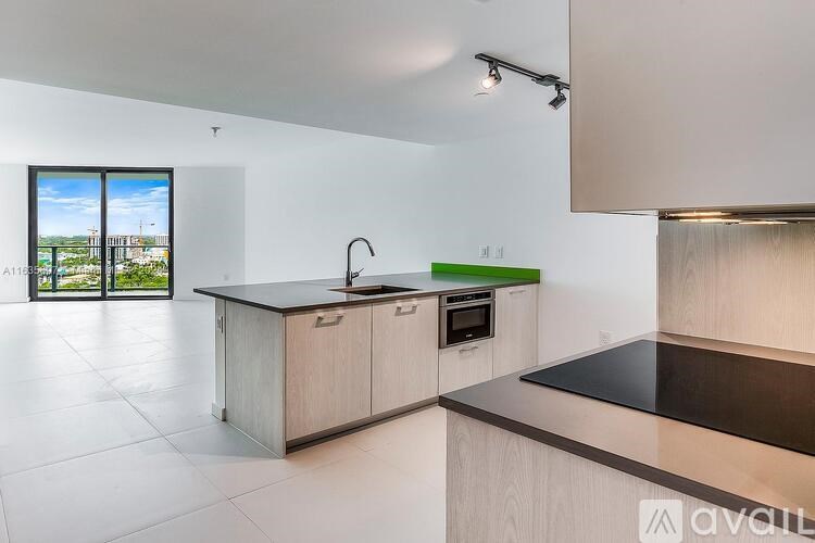 A modern kitchen with a large island and a view of the outside.