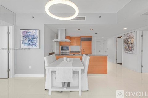 A modern kitchen with a dining table and chairs.