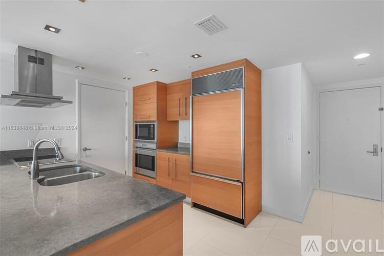 A modern kitchen with wooden cabinets and a stainless steel sink.