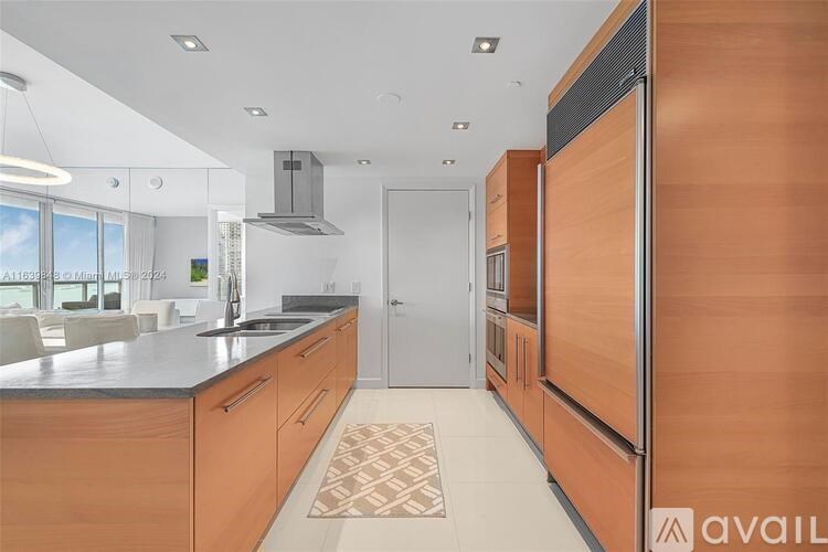 A kitchen with wooden cabinets and a black countertop.