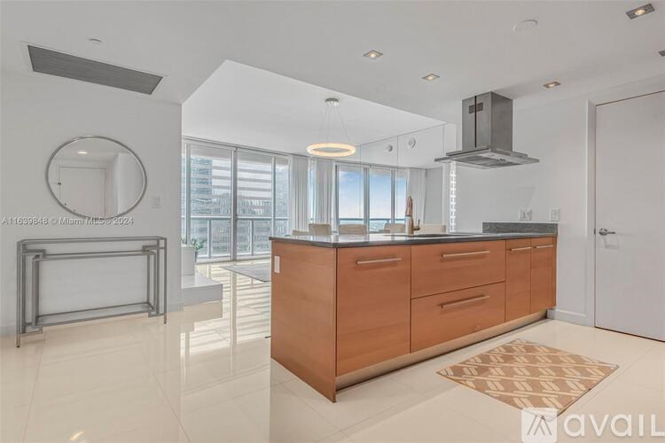 A modern kitchen with wooden cabinets and a large window.