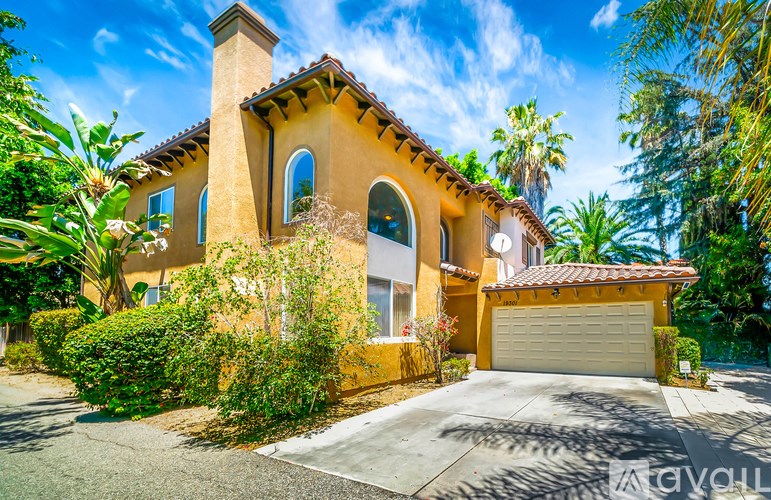 A house with a brown stucco exterior and a white garage door.