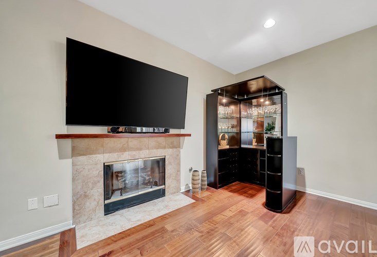 A modern living room with a fireplace and a flat screen TV mounted above it.