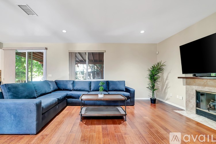 A living room with a blue couch and a fireplace.