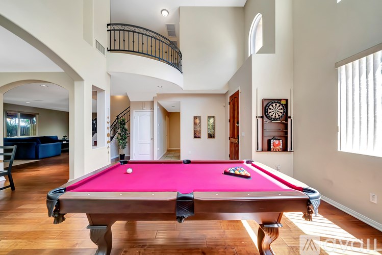 A pool table in a room with a balcony.