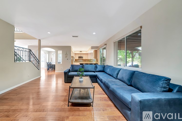 A living room with a blue couch and wooden floors.