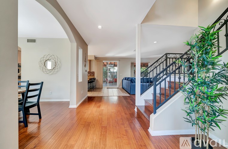 A living room with a staircase and a dining table.