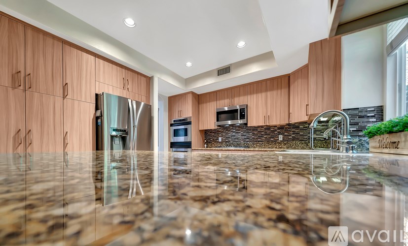 A kitchen with wooden cabinets and a marble countertop.